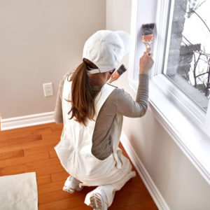 Window trim - a photo of a woman painting window trim.